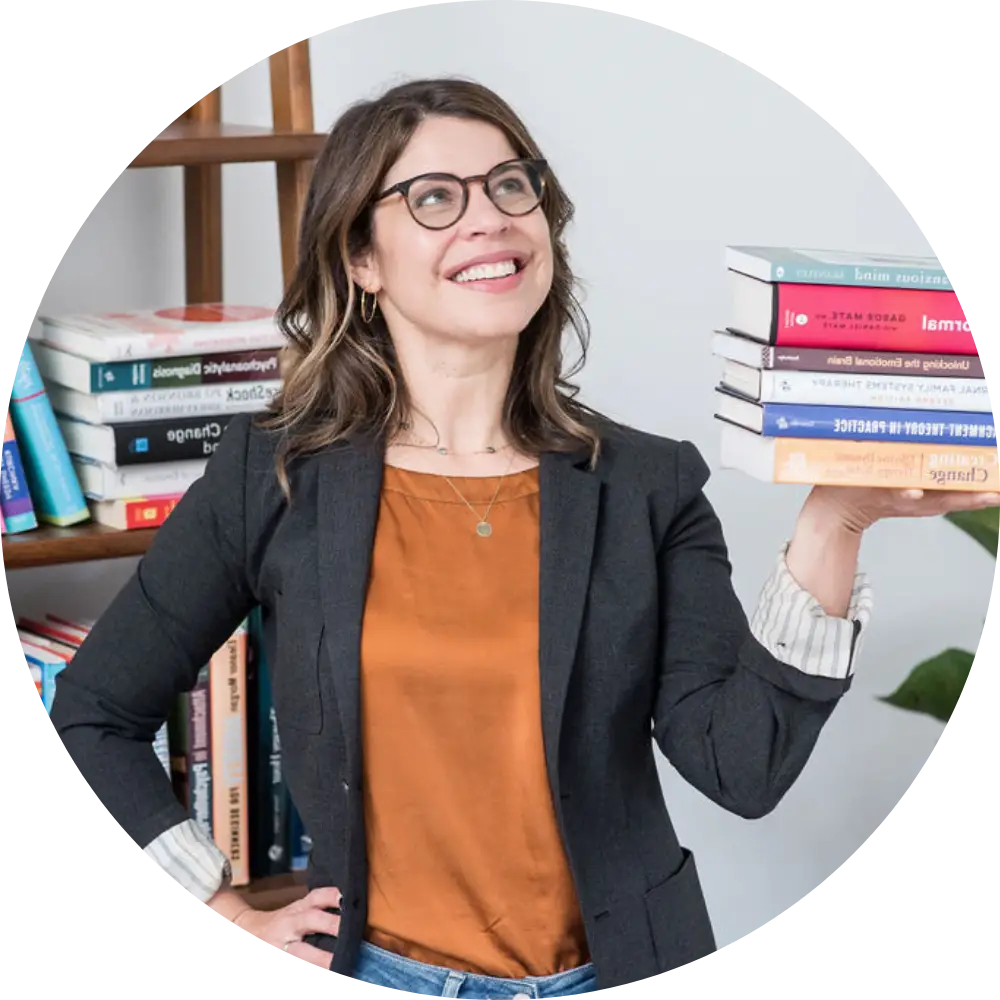 Elana Sures, Clinical Supervisor, holding a stack of Books