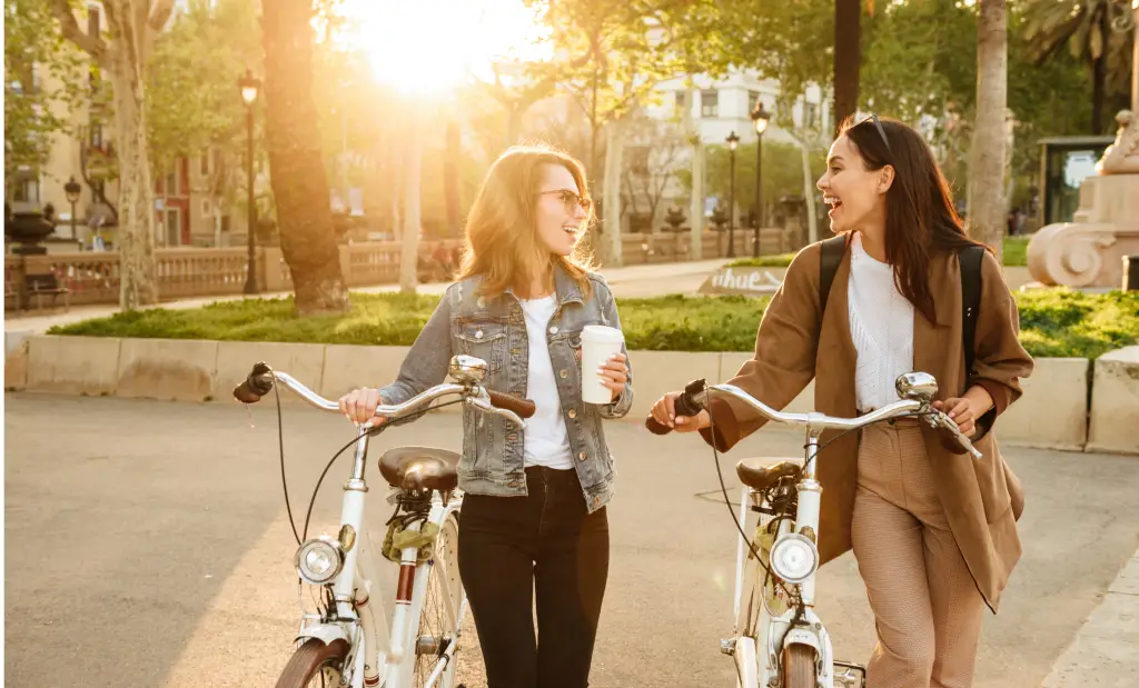 Girls walking in Vancouver holding bikes and smiling