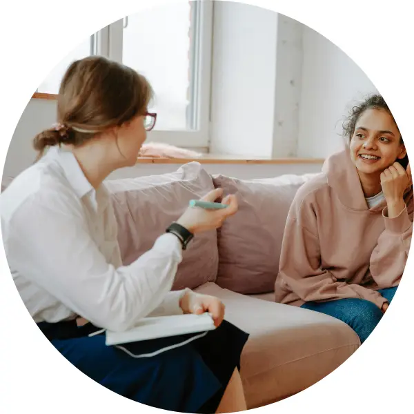 A teen talking to a counsellor looking happy.