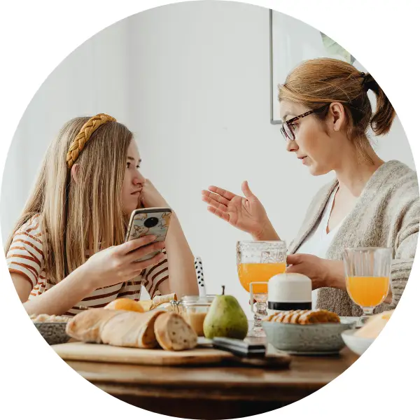 Girl talking to her mom at the dining room table.